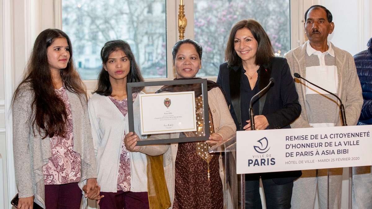 Asia Bibi a Pakistani Christian woman, center, poses her daughters Eisham, 2nd left, Eisha, left, her husband Ashik, right, and Paris' mayor Anne Hidalgo after she received the diploma as a Citizen of Honor of the city of Paris at the City Hall, Tuesday, Feb. 25, 2020. (AP Photo/Michel Euler)
