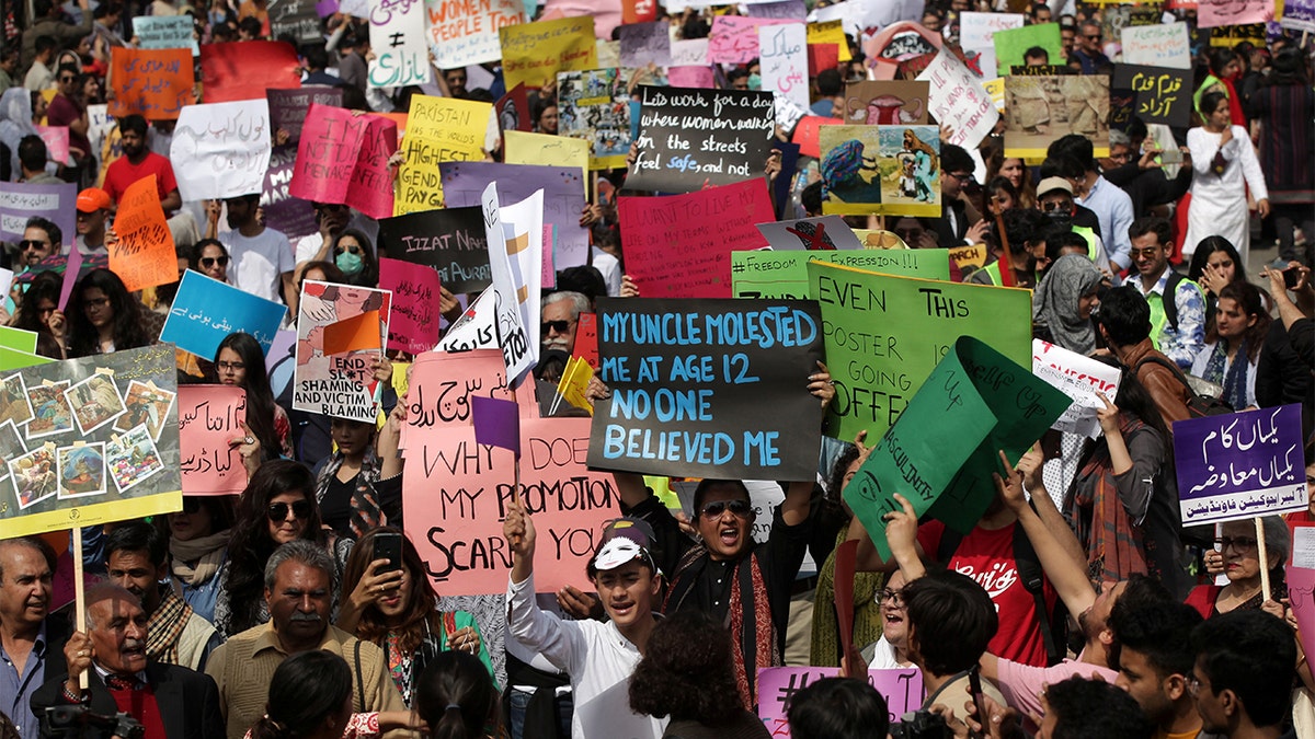 Women and men carry signs as they take part in an Aurat March, or Women's March in Lahore, Pakistan March 8, 2020. REUTERS/Mohsin Raza - RC2QFF9VF0E2