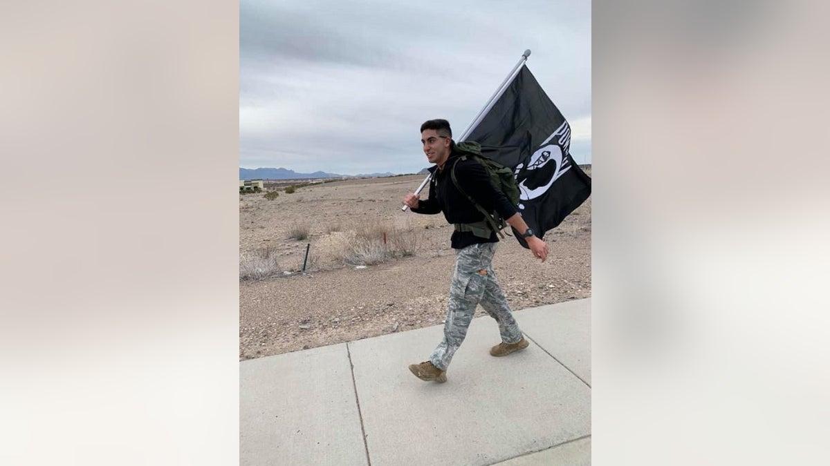 Airman David Saenz, 21, holds a Prinsoers of War flag while walking the streets of Las Cruces, N.M on Sunday.