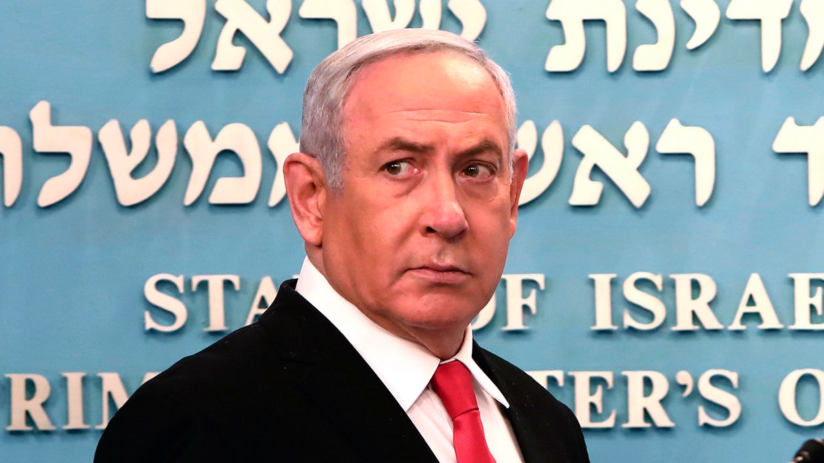 Prime Minister Benjamin Netanyahu approaches the podium to speak from his Jerusalem office on Saturday, March 14, 2020. (Associated Press)