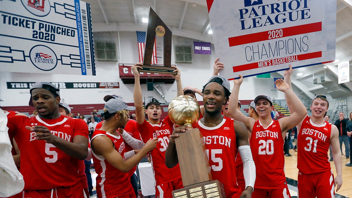 Boston University's Jonas Harper (15) holds the trophy after beating Colgate in the NCAA Patriot League Conference basketball championship at Cotterell Court, Wednesday, March 11, 2020, in Hamilton, N.Y. (AP Photo/John Munson)