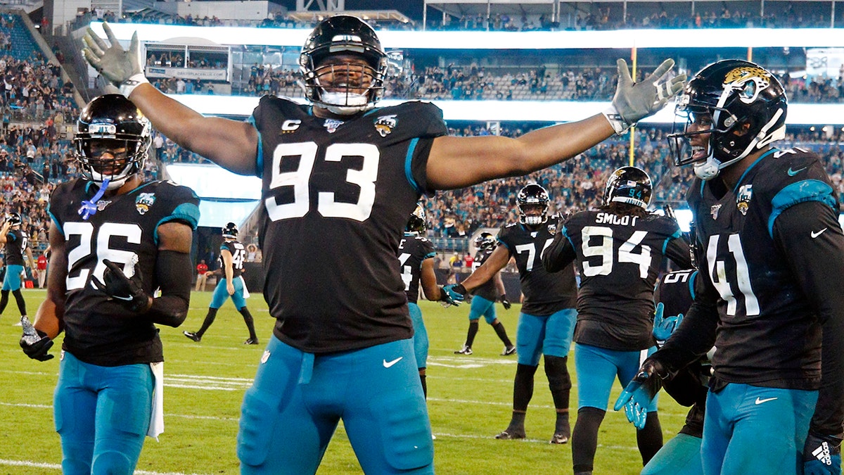 Ex-Jacksonville Jaguars defensive end Calais Campbell (93) celebrates his touchdown against the Indianapolis Colts on a fumble recovery with safety Jarrod Wilson (26) and linebacker Josh Allen (41) during the second half of an NFL football game, in Jacksonville, Fla. On Sunday, March 15, 2020, the Baltimore Ravens agreed to trade a fifth-round draft pick in the upcoming draft to the Jacksonville Jaguars for veteran defensive lineman Calais Campbell. (AP Photo/Stephen B. Morton, File)