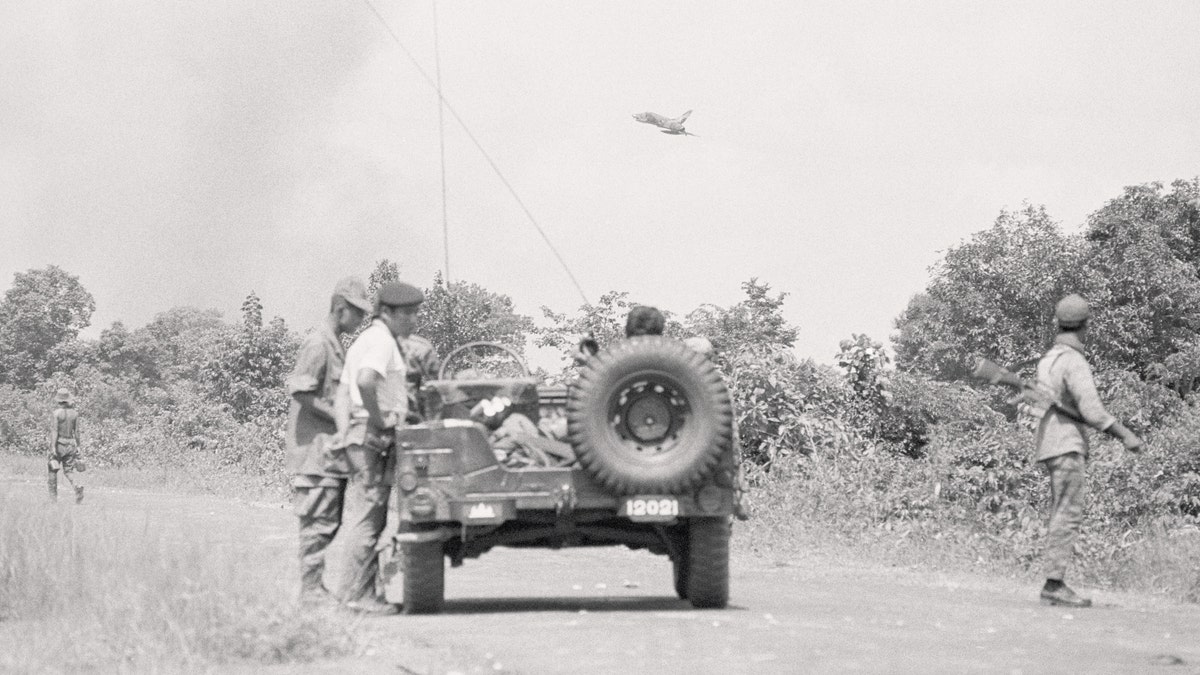 An American F-100 jet comes in low to drop napalm on Communist positions near Skoun, Cambodia. The strike was coordinated by the Cambodians in the jeep. (Getty/Bettmann/File)