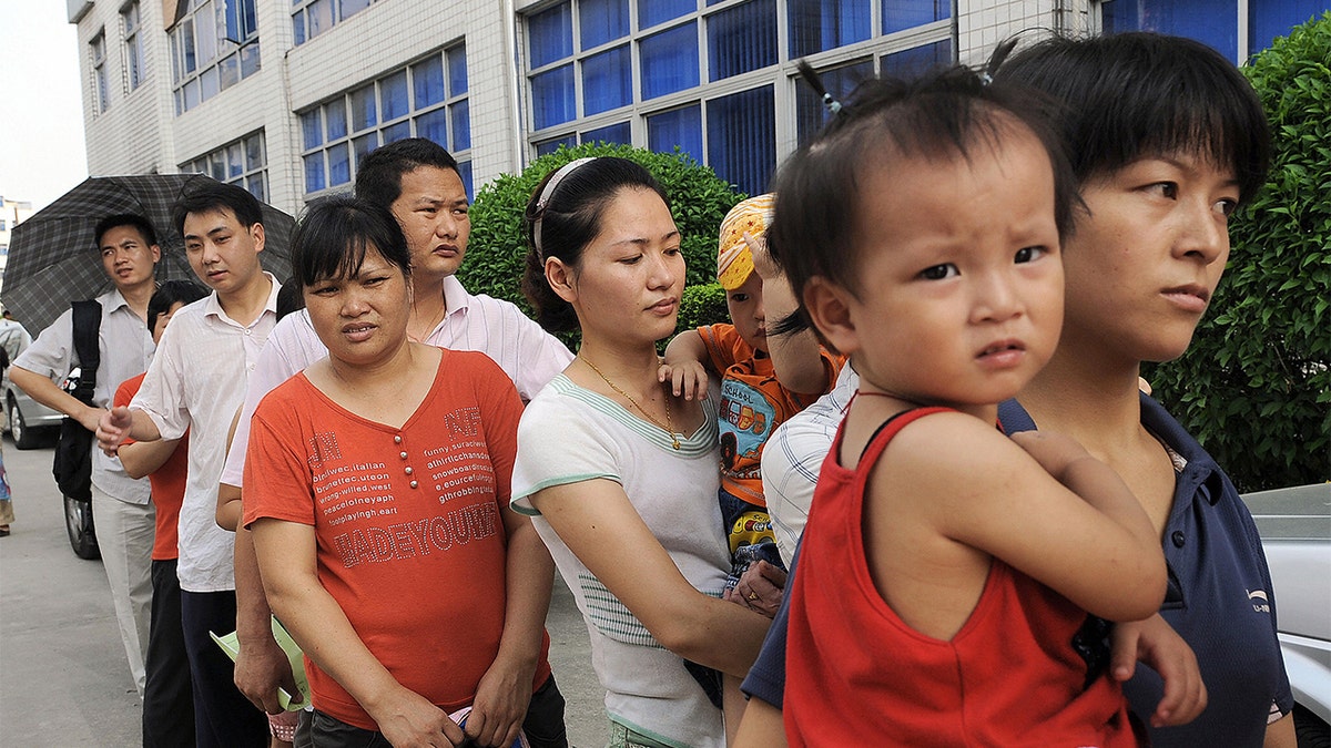 Parents queue up to have their children checked at Longgang central hospital in Shenzhen on Sept. 21, 2008 amidst a tainted milk scandal that killed four babies. (Photo credit should read TED ALJIBE/AFP via Getty Images)