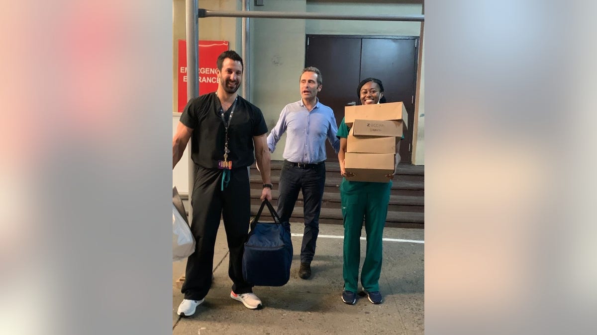Luca Di Pietro, owner of Tarallucci e Vino, stands with two health-care workers and a stack of donated meals from his restaurant. (Photo courtesy Luca Di Pietro)