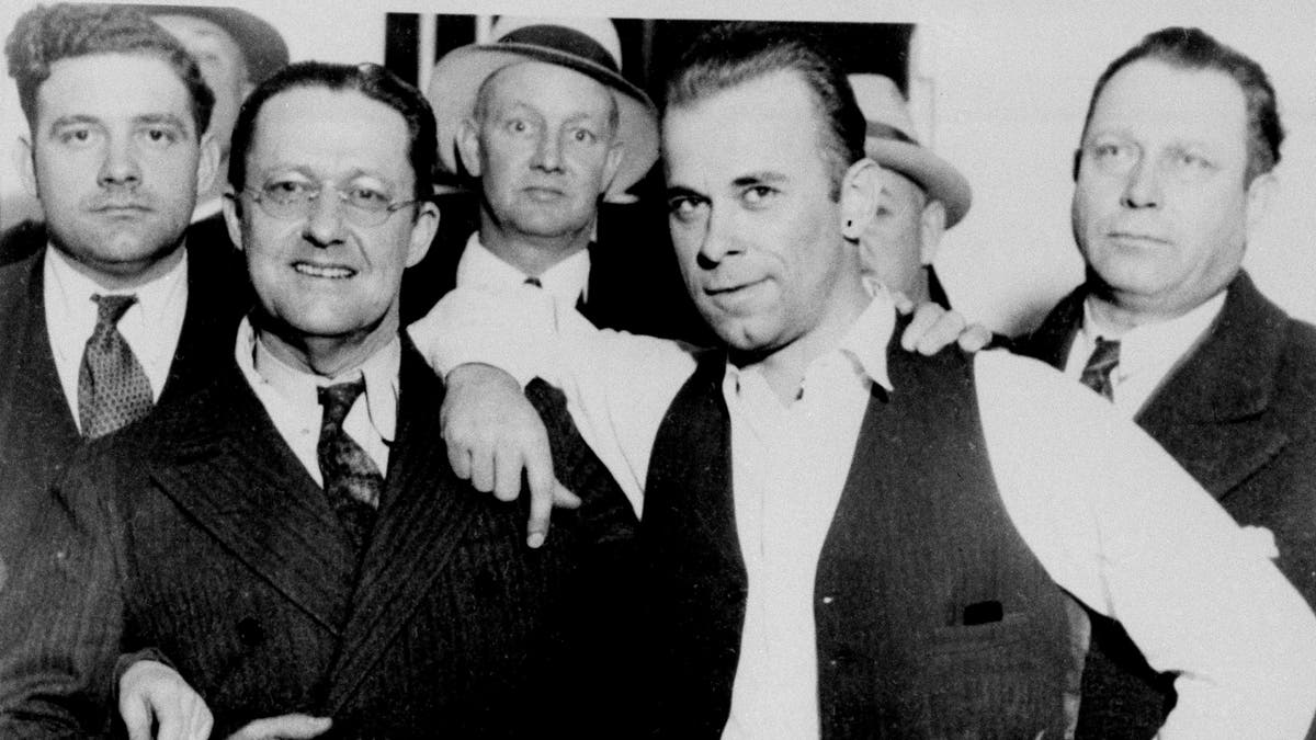 Captured desperado John Dillinger, wearing vest, strikes a jaunty pose with prosecutor Robert Estill in what would become an infamous image at the Crown Point, Ind., jailhouse, Feb. 1934. (AP Photo)