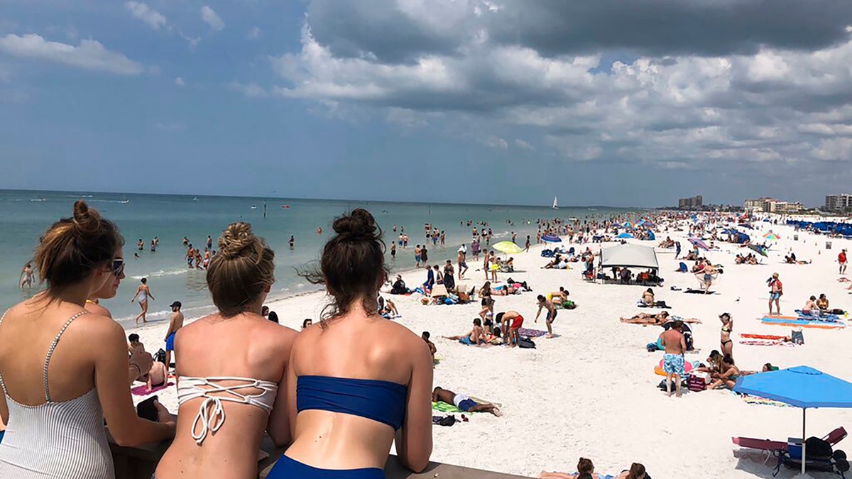 In this photo provided by Sarah J. Hollenbeck, people gather at Clearwater Beach in Florida, Monday, March 16, 2020.