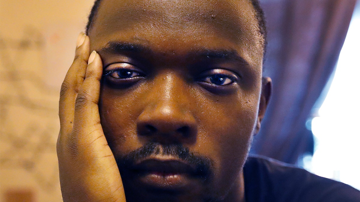 In this Thursday, Feb. 27, 2020, photo, Richard Butler poses for a portrait in an apartment that a friend is letting him and his fiance live in on Chicago's Southside.  (AP Photo/Charles Rex Arbogast)