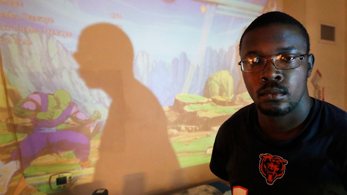 In this Thursday, Feb. 27, 2020, photo, Richard Butler poses for a portrait during a break playing a video game in an apartment that a friend is letting him and his fiance live in on Chicago's Southside. Having food stamps offers Butler a stability he's rarely known in his 25 years. (AP Photo/Charles Rex Arbogast)