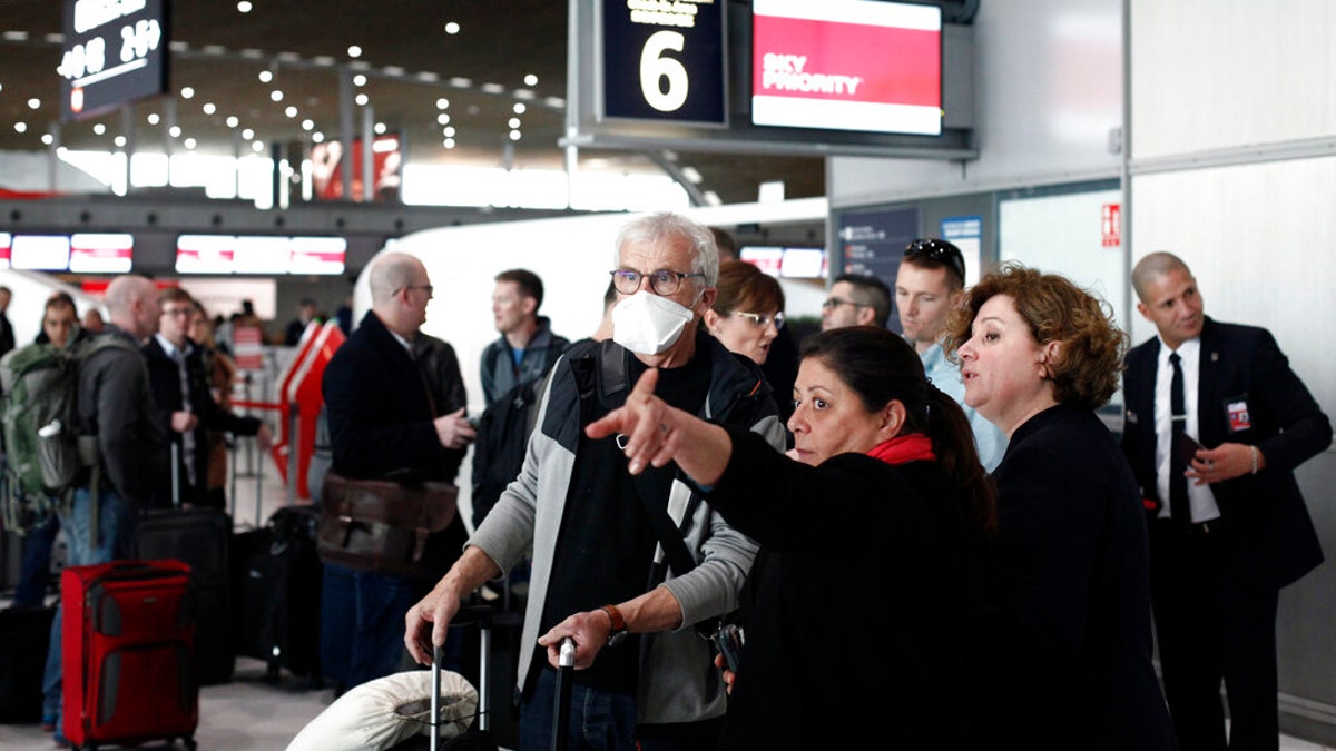 Passengers await flights out of Charles de Gaulle airport, north of Paris, on March 12, 2020, following President Trump's decision to restrict travel from 26 European nations.