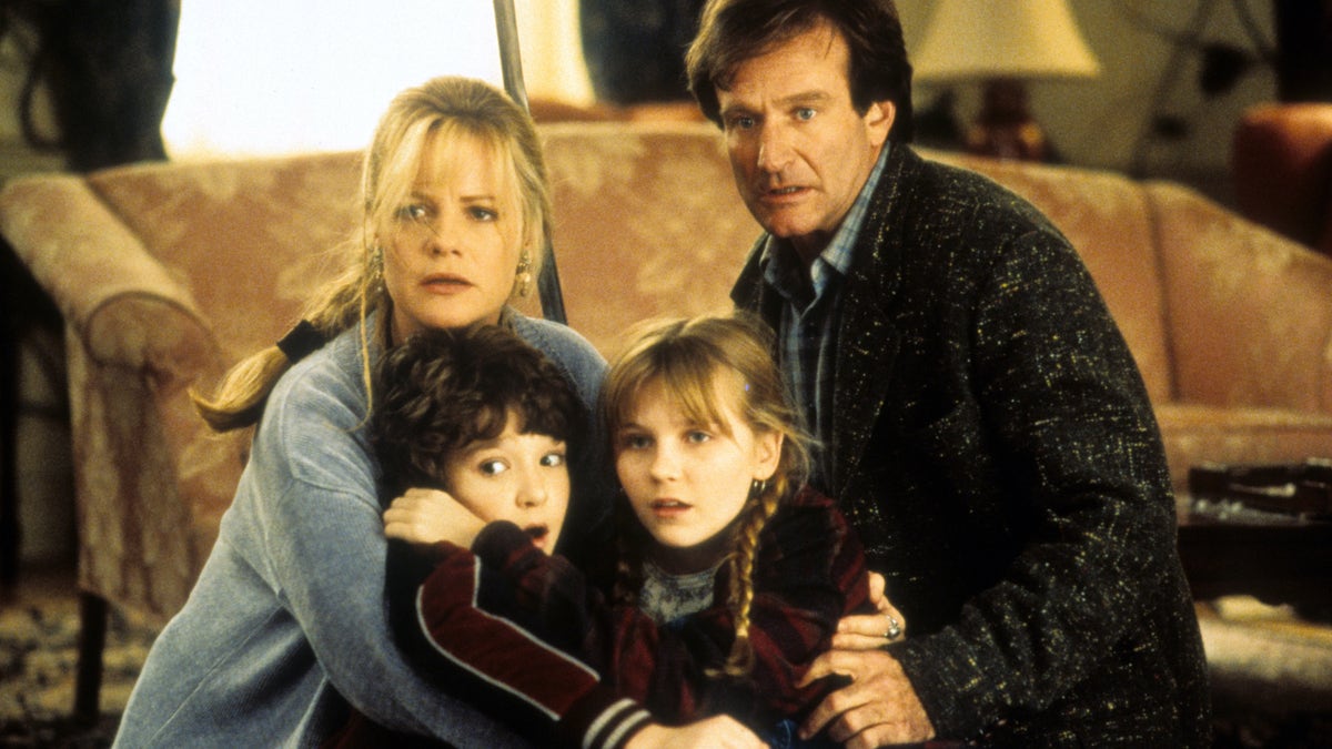 Bonnie Hunt, Bradley Pierce, Kirsten Dunst and Robin Williams (L -R) hold each other in a scene from the film 'Jumanji' in1995.