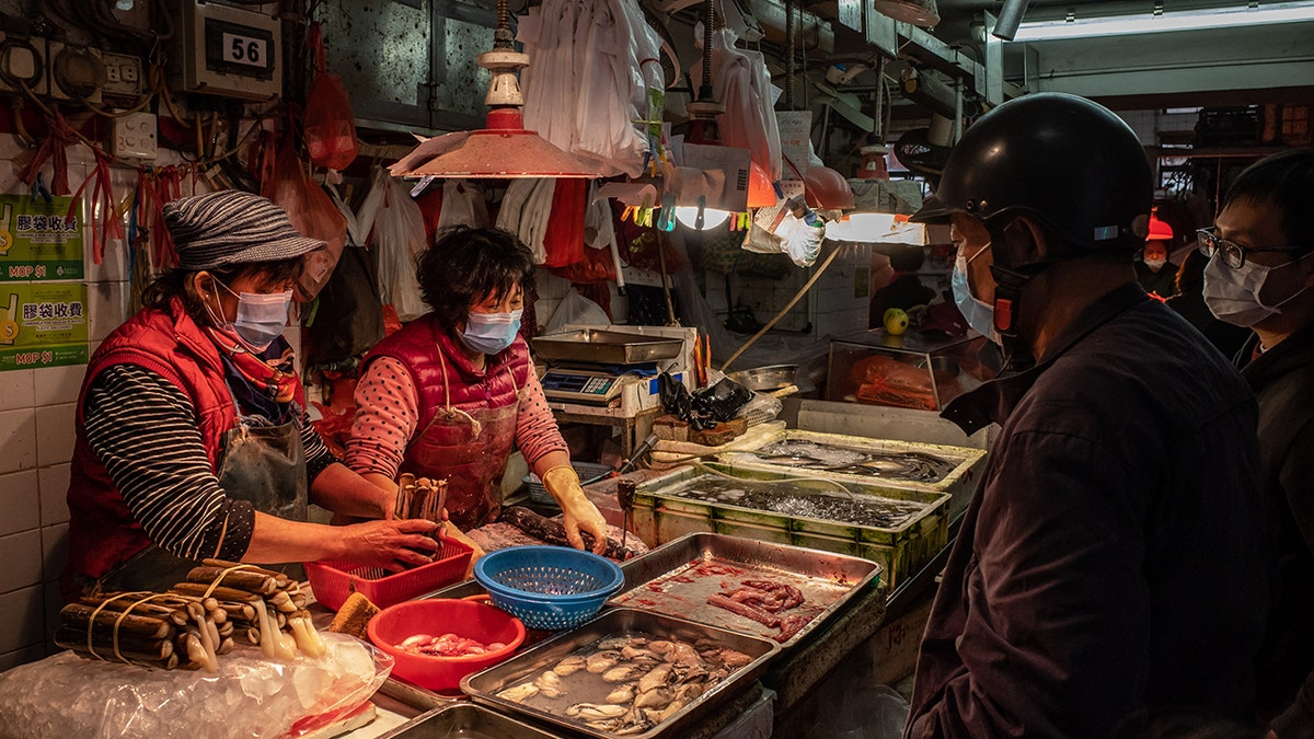 Residents wearing face masks purchase seafood at a wet market on Jan. 28 in Macau, China.
