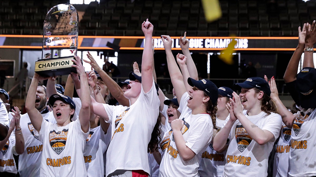 Members of the IUPUI team hoist the trophy after they defeated Green Bay 61-37 in an NCAA college basketball game for the Horizon League women's tournament championship in Indianapolis, Tuesday, March 10, 2020. (AP Photo/Michael Conroy)