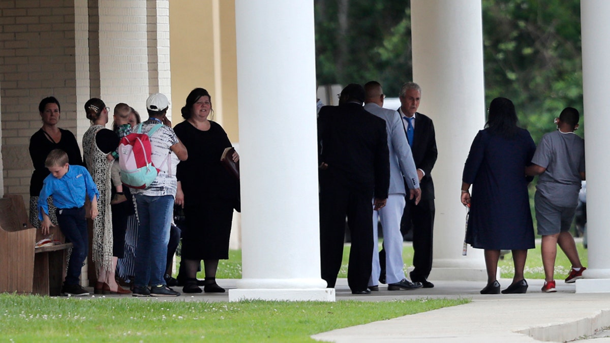 Congregants gather after services at the Life Tabernacle Church in Central, La., Sunday, March 29, 2020. Pastor Tony Spell has defied a shelter-in-place order by Louisiana Gov. John Bel Edwards, due to the new coronavirus pandemic, and continues to hold church services with hundreds of congregants. (AP Photo/Gerald Herbert)