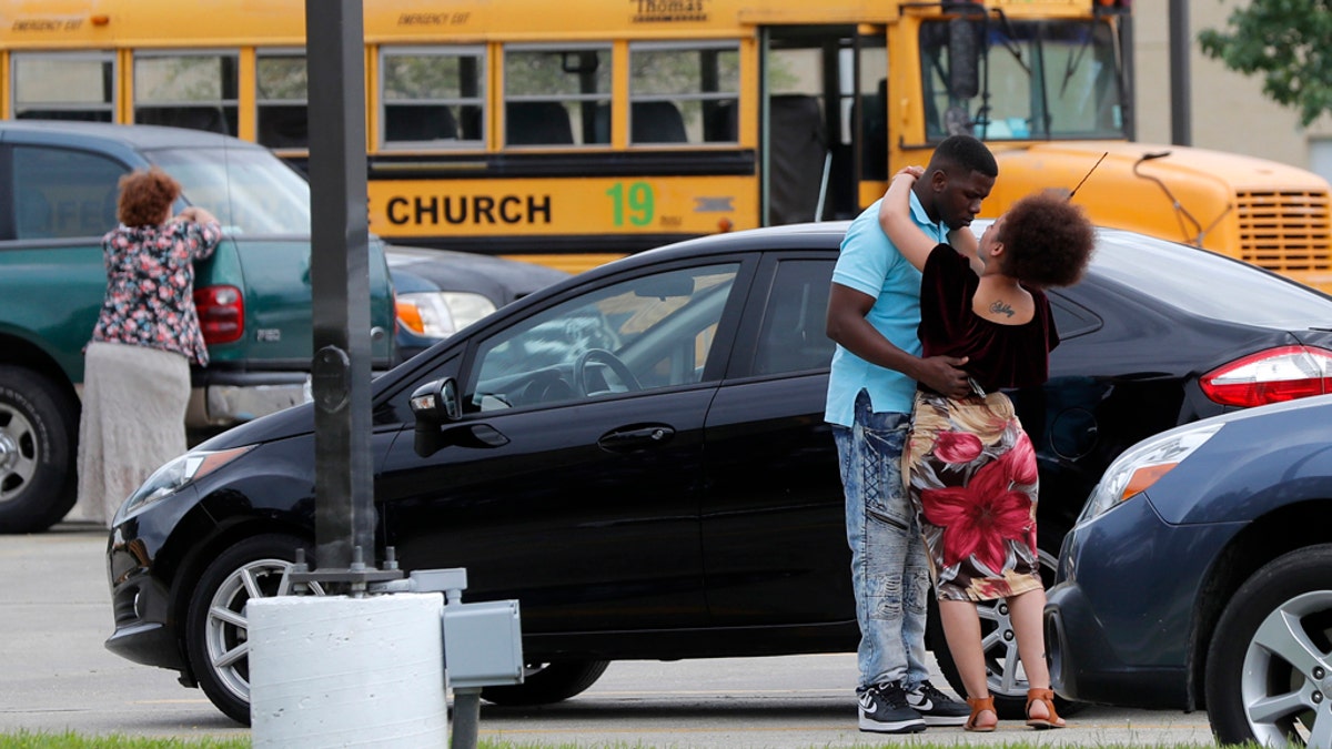 Congregants at the Life Tabernacle Church embrace after services in Central, La., Sunday, March 29, 2020. Pastor Tony Spell has defied a shelter-in-place order by Louisiana Gov. John Bel Edwards, due to the new coronavirus pandemic, and continues to hold church services with hundreds of congregants. (AP Photo/Gerald Herbert)