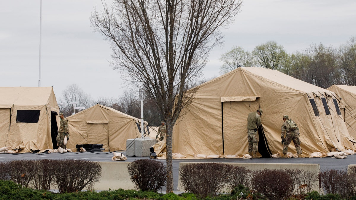 The National Guard sets up tents to be used for coronavirus testing, Saturday, March 21, 2020, in a parking lot for FedEx Field in Landover, Md., outside of Washington.