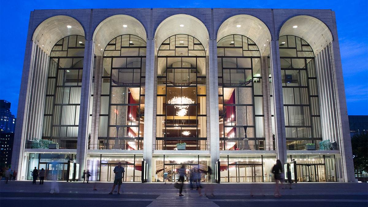 FILE - In this Aug. 1, 2014, file photo, pedestrians make their way in front of the Metropolitan Opera house at New York's Lincoln Center. The Metropolitan Opera has instituted a vaccine mandate for employees and audience members. (AP Poto/John Minchillo, File)