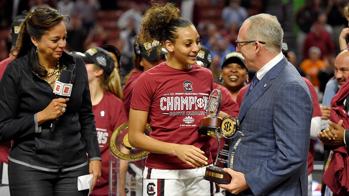 South Carolina's Mikiah Herbert-Harrigan, center, is presented with the MVP trophy by SEC Commissioner Greg Sankey, right, as ESPN's Carolyn Peck watches after defeating Mississippi State 76-62 in a championship match at the Southeastern Conference women's NCAA college basketball tournament in Greenville, S.C., Sunday, March 8, 2020. (AP Photo/Richard Shiro)