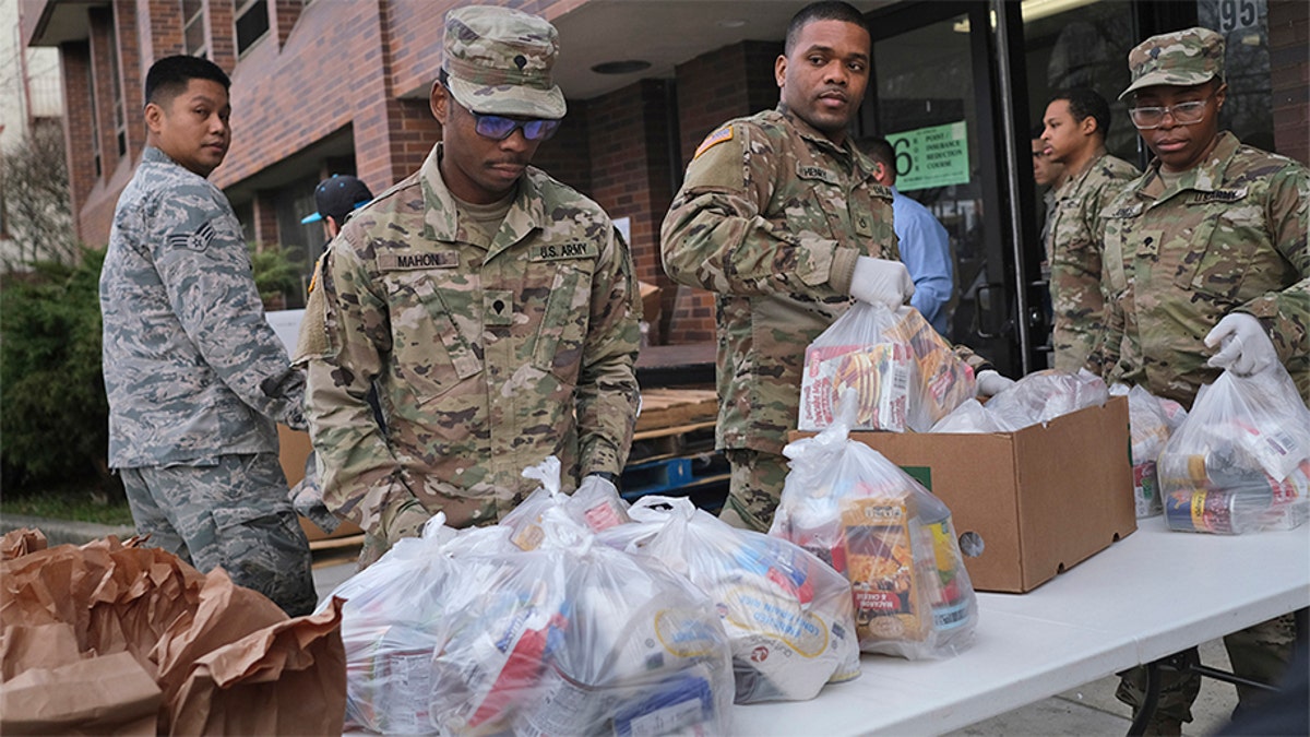Members of the New York National Guard help to organize and distribute food to families on free or reduced school lunch programs in New Rochelle, N.Y., Thursday, March 12, 2020. (Associated Press)
