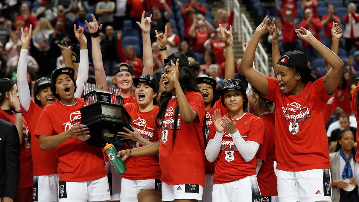 North Carolina State players celebrate with the championship trophy after defeating Florida State in the NCAA college basketball championship game at the Atlantic Coast Conference women's tournament in Greensboro, N.C., Sunday, March 8, 2020. (AP Photo/Gerry Broome)