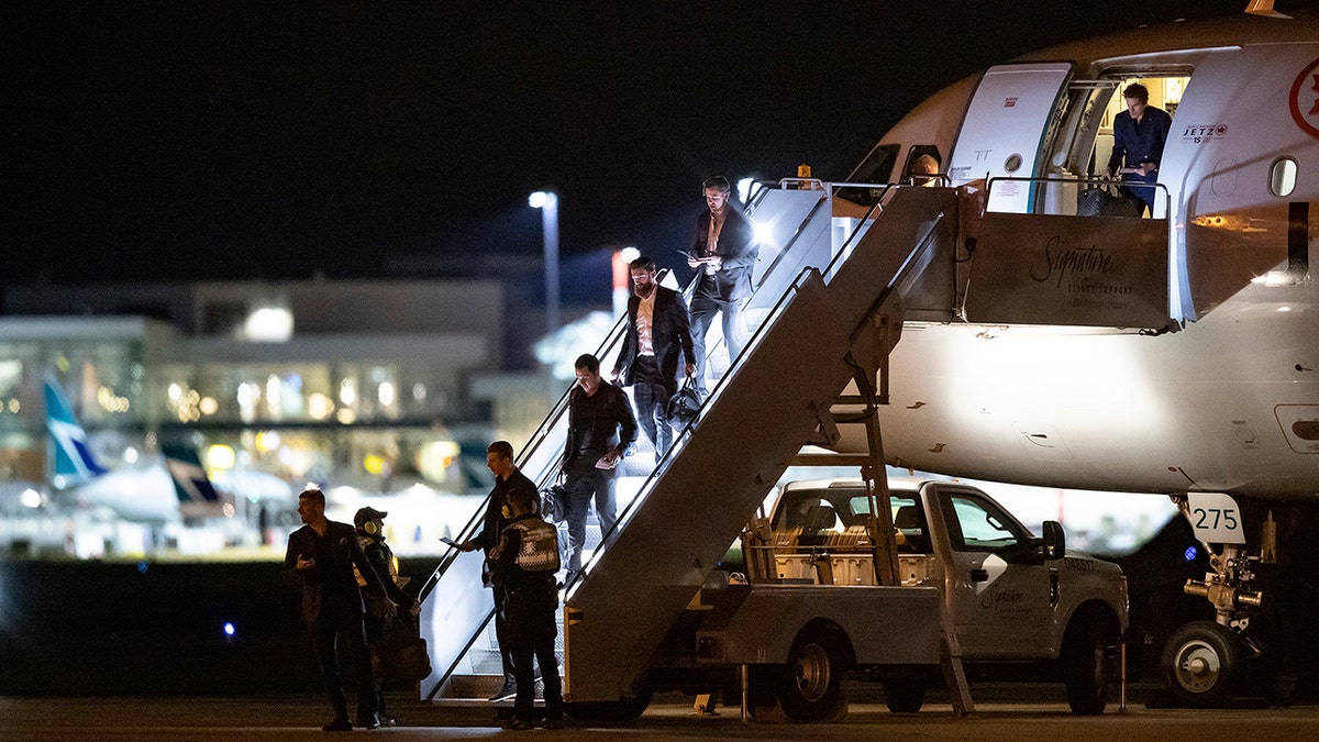 Vancouver Canucks players step off the NHL hockey team's charter plane after returning from Phoenix, at Vancouver International Airport in Richmond, British Columbia, Thursday, March 12, 2020. From bottom left are Louis Domingue, Tyler Myers, Bo Horvat, Jordie Benn, Tanner Pearson and Loui Eriksson. The NHL has suspended the season due to concerns about the new coronavirus. (Darryl Dyck/The Canadian Press via AP)