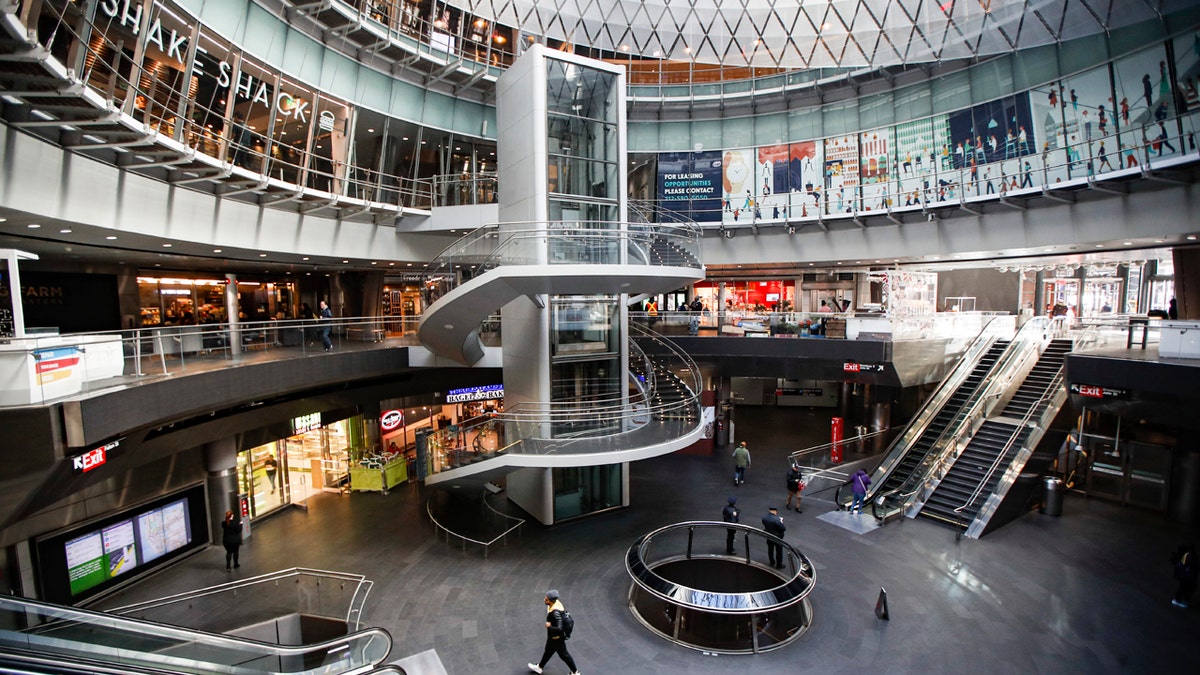 A pedestrian passes a nearly empty Fulton Center station as businesses are closed due to coronavirus concerns, Monday, March 16, 2020, in New York.