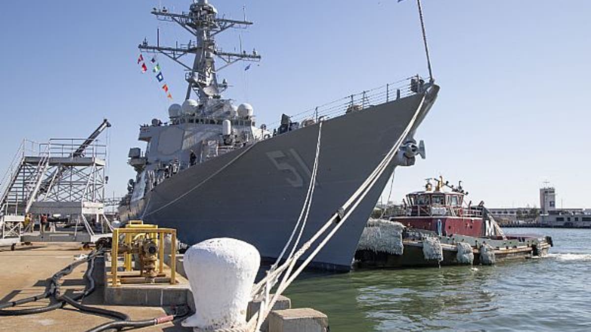 A tug boat pulls along side the guided-missile destroyer USS Arleigh Burke (DDG 51) on Jan. 27, 2020.