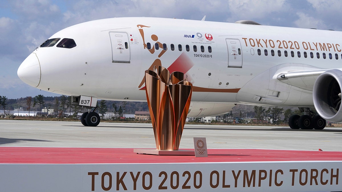 A plane carrying the Olympic flame arrives before Olympic Flame Arrival Ceremony at Japan Air Self-Defense Force Matsushima Base in Higashimatsushima in Miyagi Prefecture, north of Tokyo, Friday, March 20, 2020. The Olympic flame from Greece is set to arrive in Japan even as the opening of the the Tokyo Games in four months is in doubt with more voices suggesting the games should to be postponed or canceled because of the worldwide virus pandemic. (AP Photo/Eugene Hoshiko)