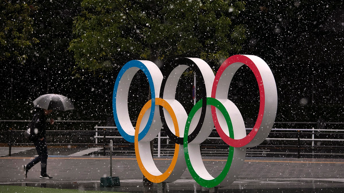 Snow falls on the Olympic rings near the New National Stadium in Tokyo, Saturday, March 14, 2020. (AP Photo/Jae C. Hong)