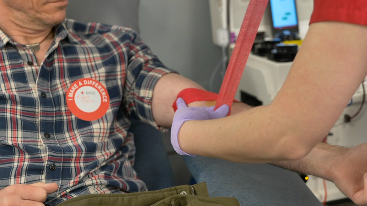 A nurse preparing a donor to give blood at a blood drive.