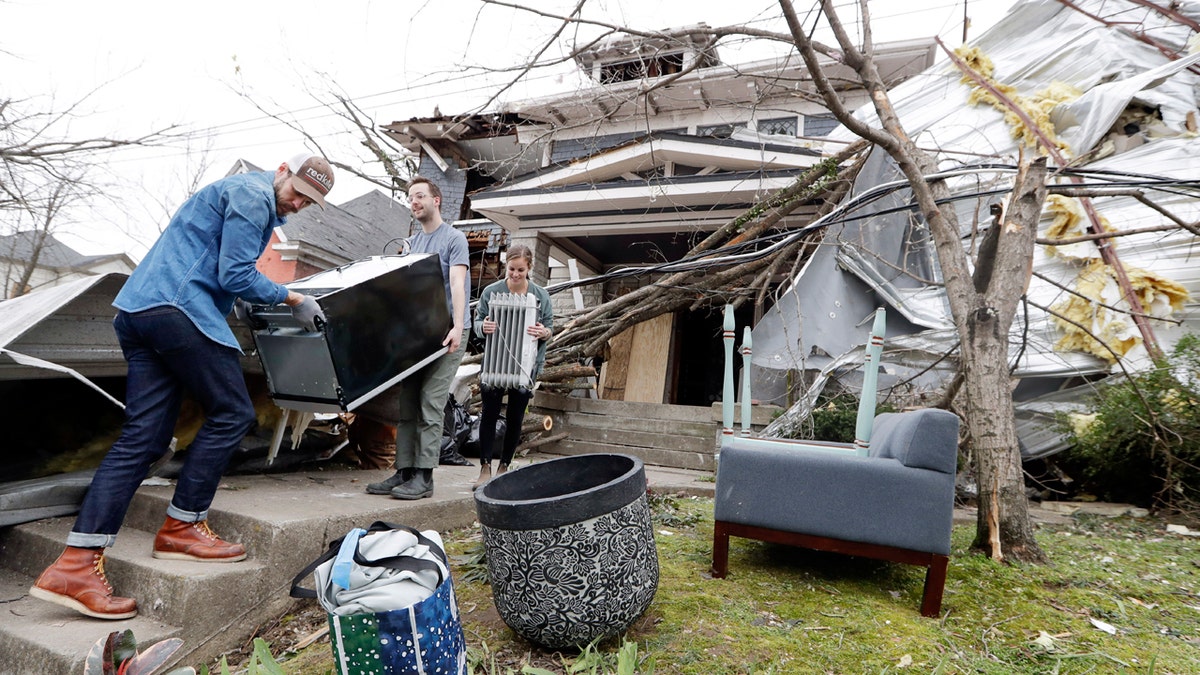 Benji Peck, left, and Austin Grove remove a refrigerator from a damaged home Wednesday, March 4, 2020, in Nashville, Tenn. Residents and businesses face a huge cleanup effort after tornadoes hit the state Tuesday.