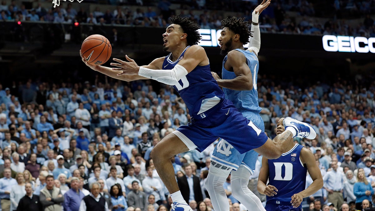 FILE - In this Feb. 8, 2020, file photo, Duke guard Tre Jones drives to the basket against North Carolina guard Leaky Black (1) during the second half of an NCAA college basketball game in Chapel Hill, N.C. Tre Jones was selected to the Associated Press All-ACC team selected Tuesday, March 10, 2020. (AP Photo/Gerry Broome, File)