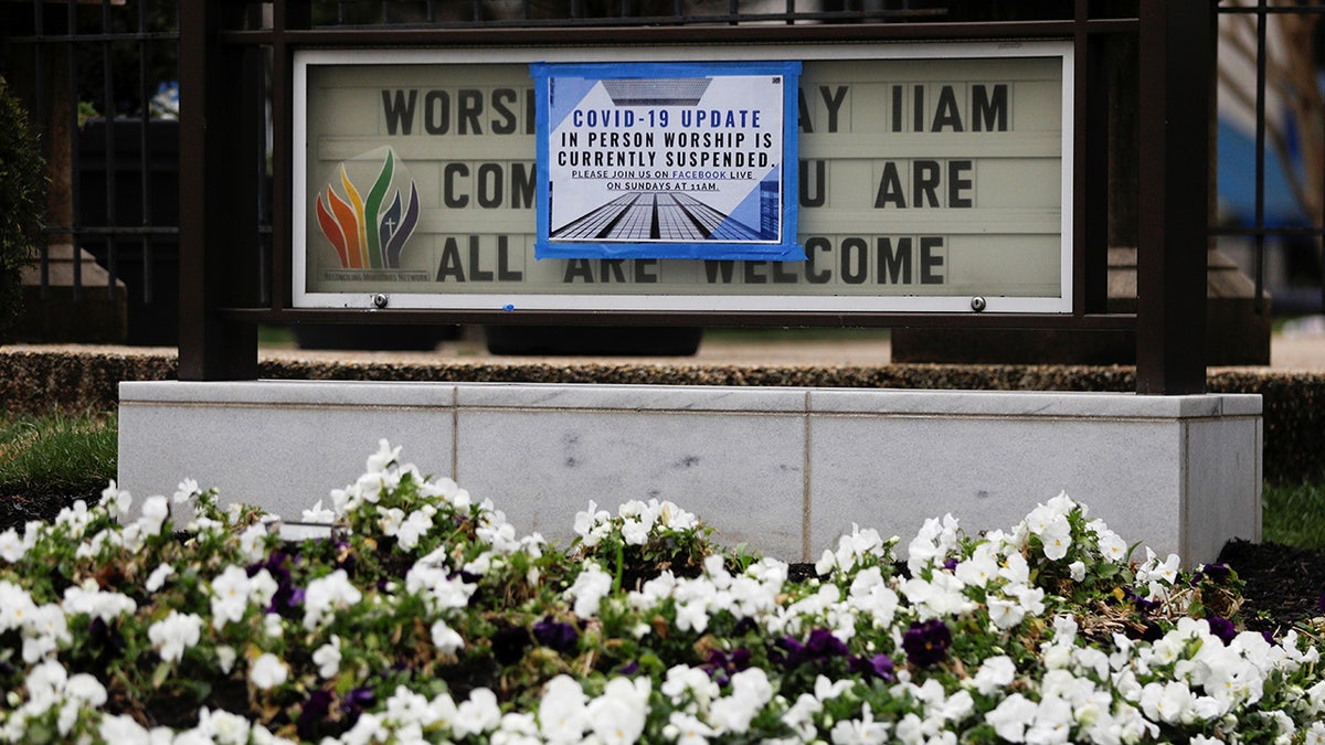 A sign displaying modified church services, due to the coronavirus disease (COVID-19) outbreak, is posted over a signboard outside Mount Vernon Place Methodist Church in the Mount Vernon neighborhood of Washington, U.S., March 19, 2020. REUTERS/Tom Brenner - RC27NF9YU070