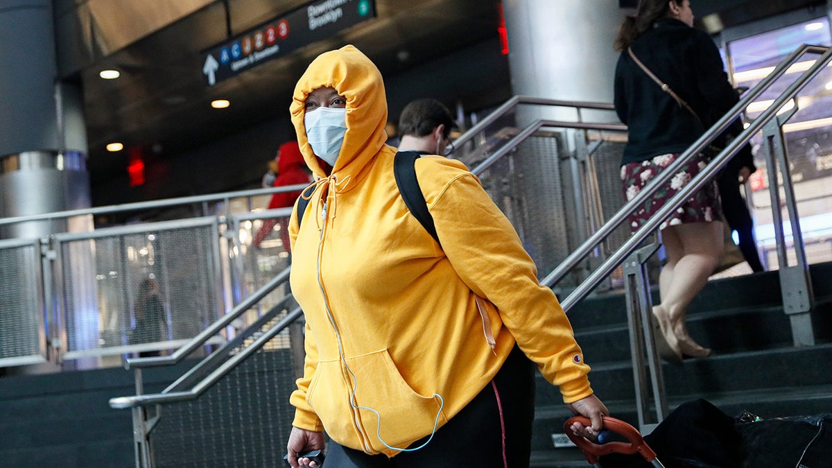A commuter wears a face mask in the New York City transit system, Monday, March 9, 2020, in New York. New York continued grappling with the new coronavirus, as case numbers, school closings and other consequences grew.
