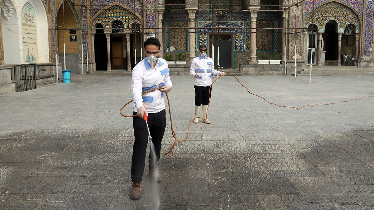 Iranian workers disinfect the shrine of the Shiite Saint Imam Abdulazim to help prevent the spread of the new coronavirus in Shahr-e-Ray, located south of Tehran, on Saturday. (AP Photo/Ebrahim Noroozi)