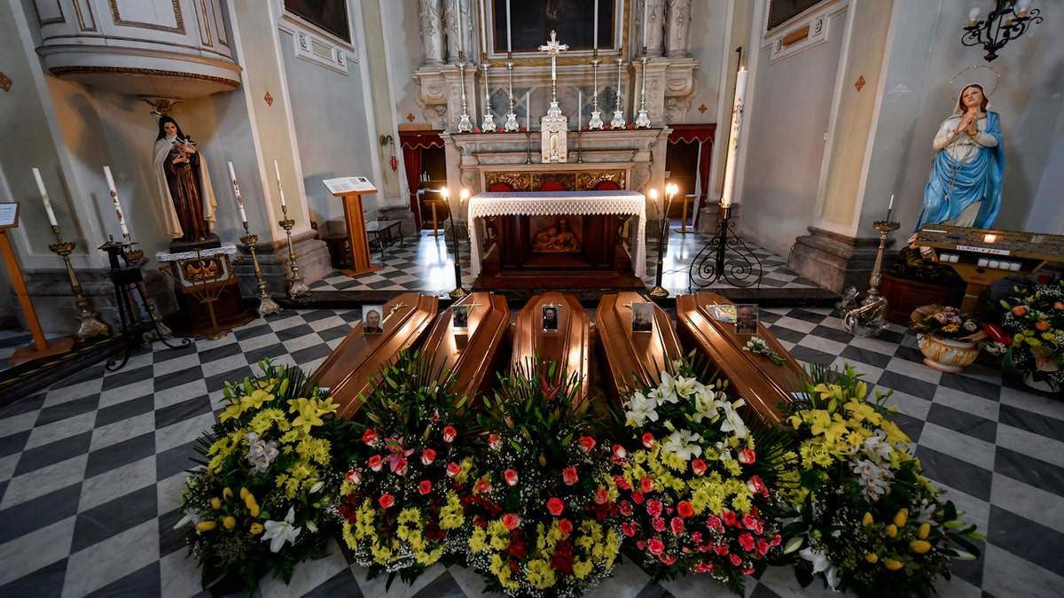 Coffins wait to be transported to cemetery, in the church of Serina, near Bergamo, Northern Italy, Saturday, March 21, 2020.