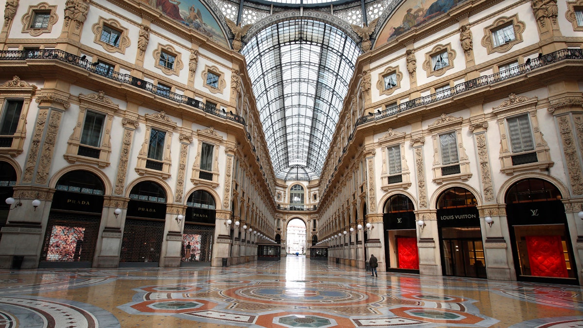 A man walks in an empty Vittorio Emanuele II gallery shopping arcade, in downtown Milan, Italy, Sunday, March 22, 2020.