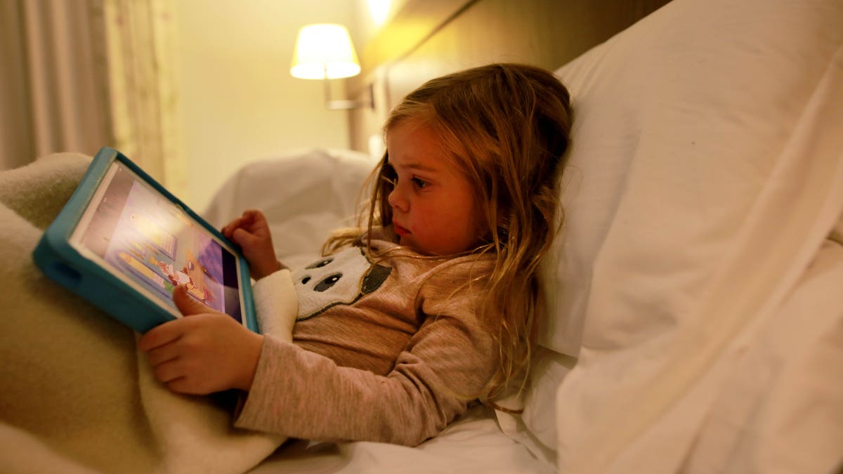 little girl plays on iPad