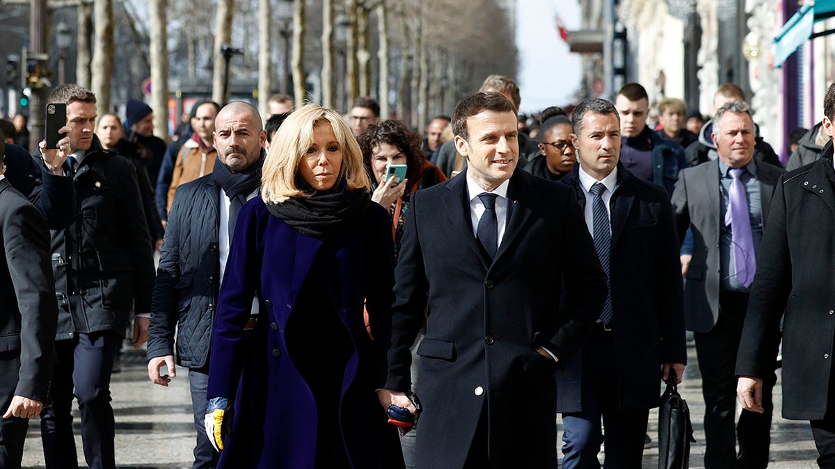 French President Emmanuel Macron and his wife Brigitte Macron on Monday walked down Paris' famous Champs-Elysees avenue in a move to send a message of confidence to the French economy amid the coronavirus crisis. (Yoan Valat, Pool via AP)