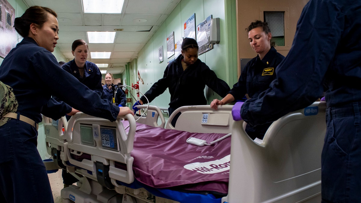 Sailors assigned to the USNS Mercy relocate patient beds after the ship was deployed support of the nation's COVID-19 response efforts, and will serve as a referral hospital for non-COVID-19 patients currently admitted to shore-based hospitals in Los Angeles.