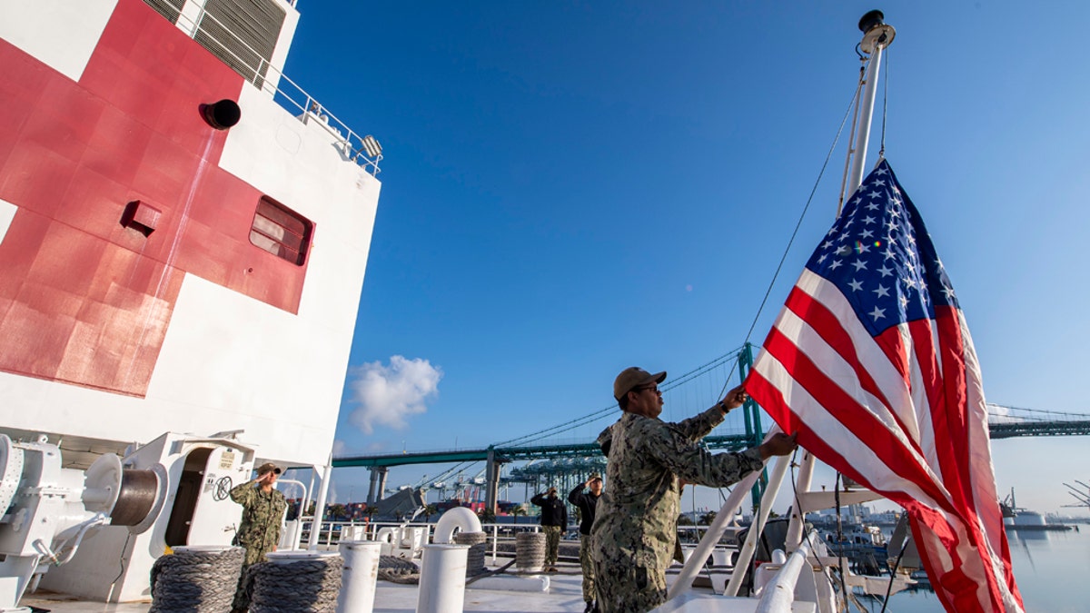 Logistics Specialist 1st Class Tavares Littleton, from Chicago, raises the American flag during morning colors aboard the hospital ship USNS Mercy on Sunday in Los Angeles.