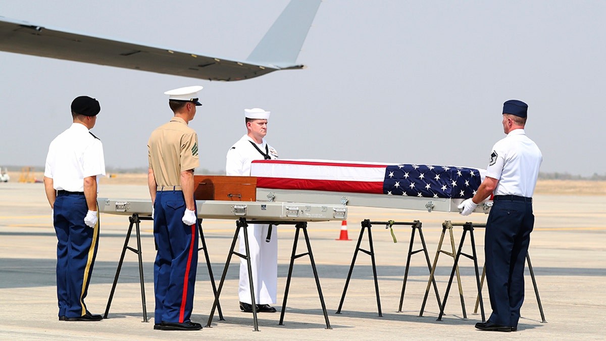 U.S. military guard of honor prepare to carry a coffin covered with U.S. national flag during repatriation ceremony at Mandalay International Airport Thursday, in Mandalay, central Myanmar. The U.S. military has repatriated what may be the remains of service personnel who were lost in action in Myanmar during World War II.  (AP Photo/Thein Zaw)