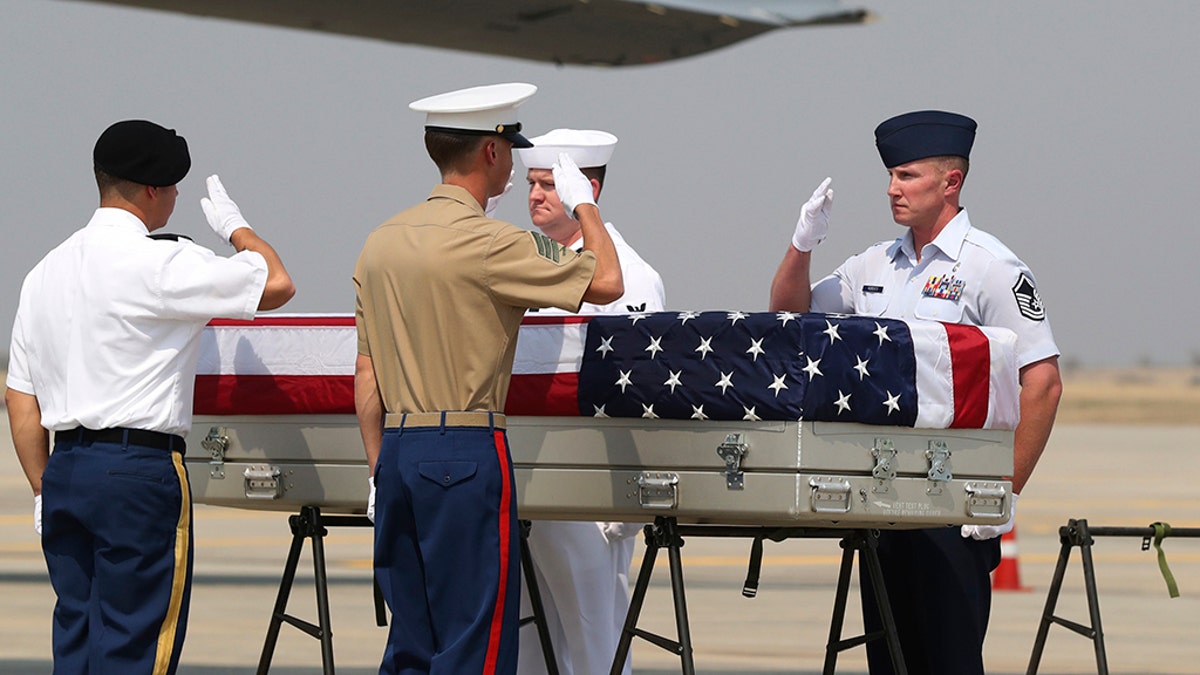 U.S. military guard of honor salute a coffin covered with U.S. national flag during a repatriation ceremony at Mandalay International Airport Thursday, March 12, 2020, in Mandalay, central Myanmar.  (AP Photo/Thein Zaw)