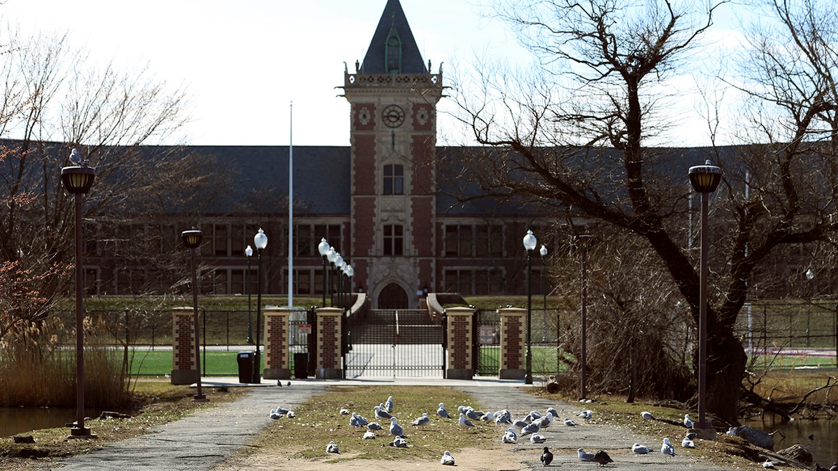 This photo shows the front gate of the New Rochelle High School, situated inside what's called a "containment area," Wednesday, March 11, 2020 in New Rochelle, N.Y. The school is among the nine closed as a precaution to contain the virus' spread. State officials on Tuesday called for closing schools, houses of worship and any other spaces were large numbers of people gather within a 1-mile radius of a point near a synagogue where an infected person had attended events.