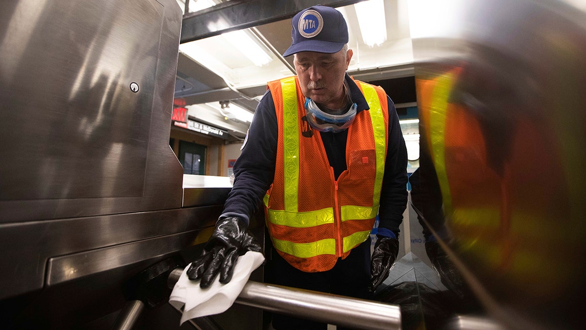 Worker Duane Clark works to sanitize surfaces at the Avenue X subway station on Tuesday in the Brooklyn borough of New York. (AP Photo/Kevin Hagen)