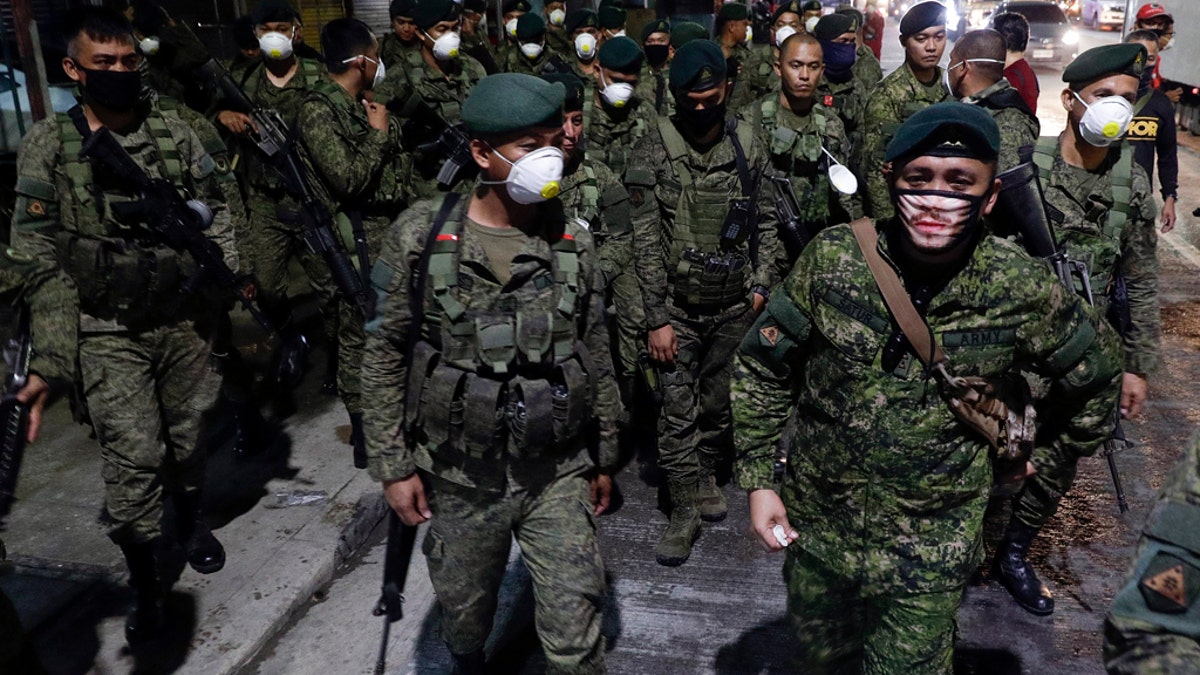 Thousands of Philippine police, backed by the army and coast guard, on Sunday worked to seal the densely populated capital, Manila, from most domestic travelers in one of Southeast Asia's most drastic containment moves against the coronavirus. (AP Photo/Aaron Favila)