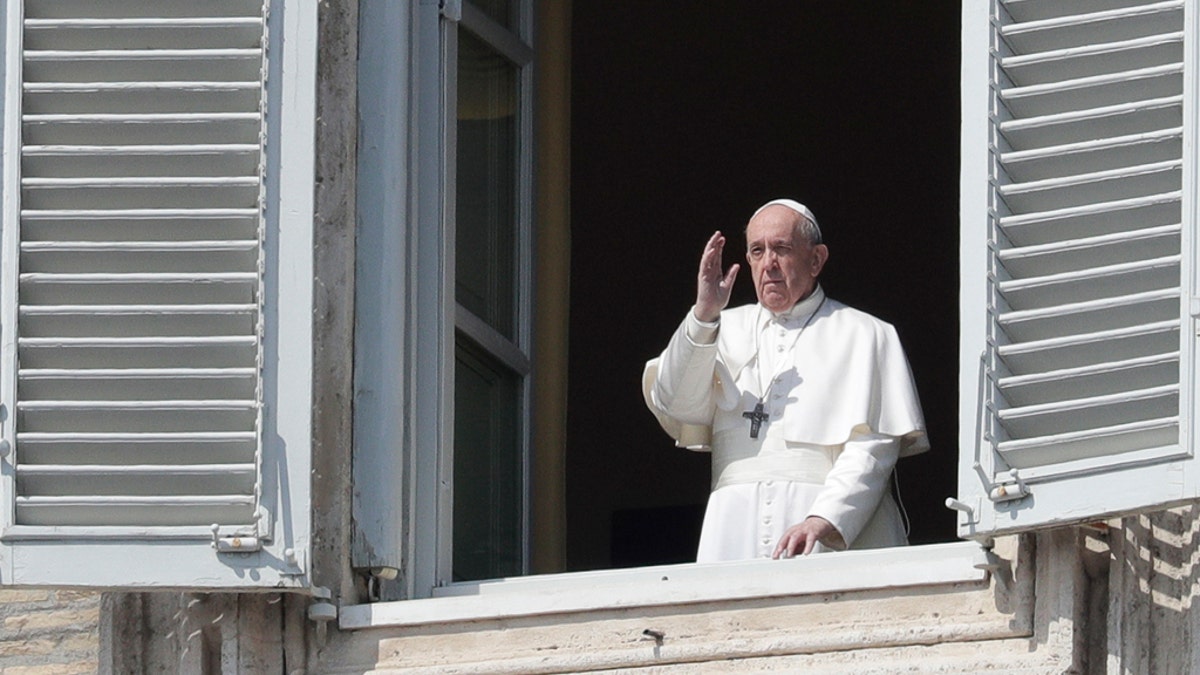 Pope Francis delivers his blessing from the window of his private library overlooking St. Peter's Square, at the Vatican, Sunday, March 22, 2020. (AP Photo/Andrew Medichini)