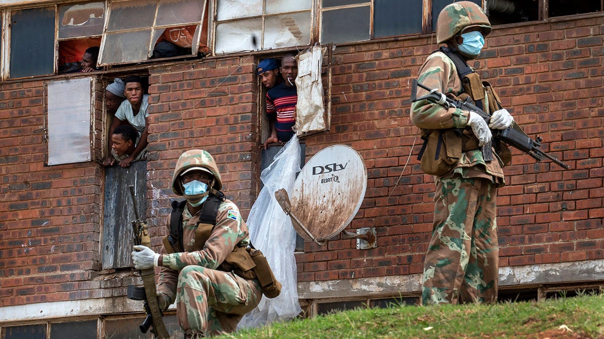 South African National Defense Forces patrol the Men's Hostel in the densely populated Alexandra township east of Johannesburg on Saturdayto enforce a strict lockdown in an effort to control the spread of the coronavirus. (AP Photo/Jerome Delay)