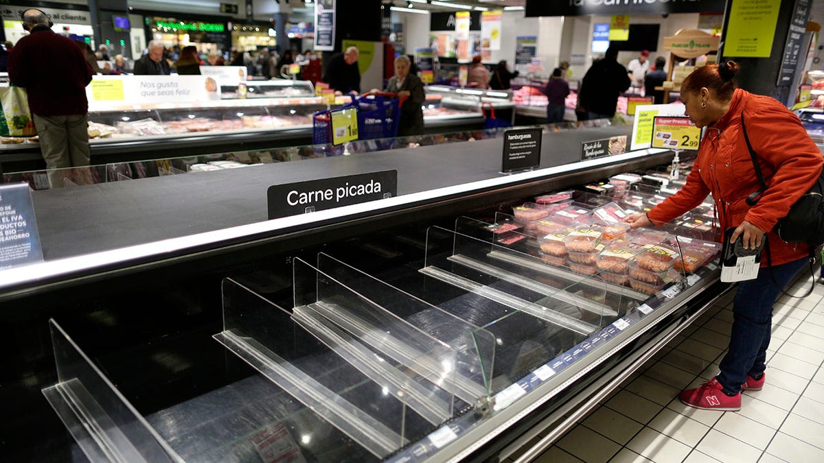 Empty shelves are seen in a supermarket as people begin to stock up on provisions in Madrid on Tuesday. (AP Photo/Manu Fernandez)