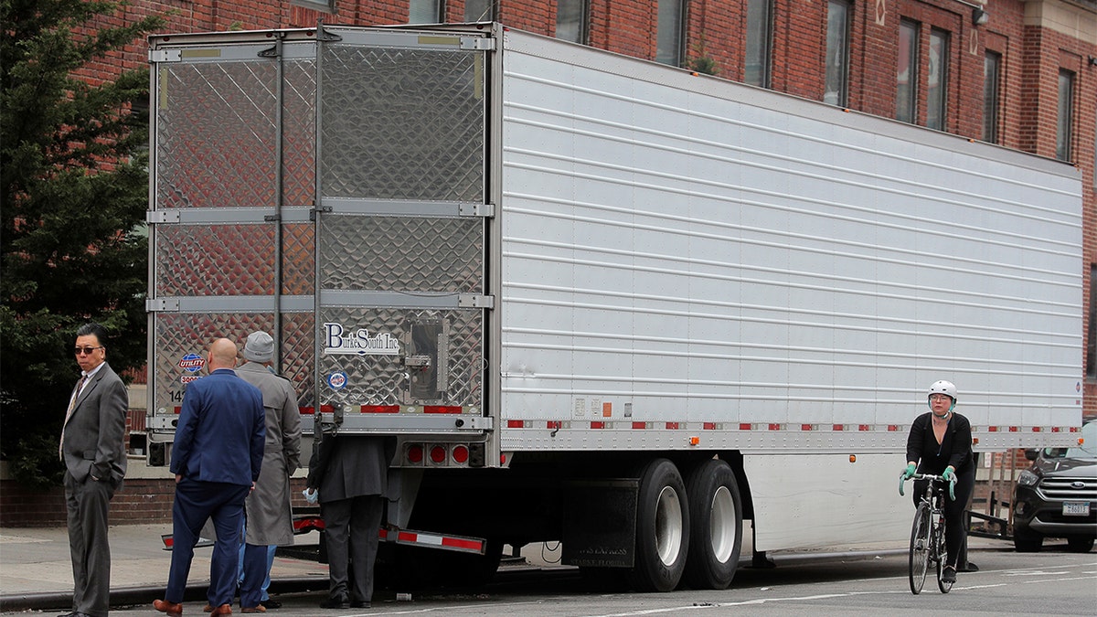 Hospital and public health officials look inside a Freezer truck at the Brooklyn Hospital Center, during the coronavirus disease (COVID-19) outbreak, in Brooklyn, New York City, U.S., March 30, 2020.